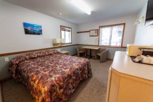 Bed, sitting area and microwave in unit at Peaks Lodge in Revelstoke, BC