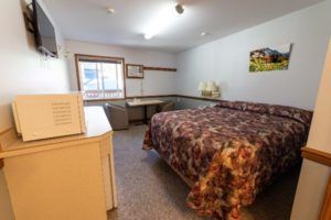Bed, sitting area of a unit at Peaks Lodge in Revelstoke, BC