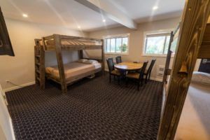 Bunk beds and dining area at Peaks Lodge in Revelstoke, BC
