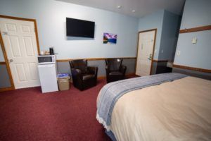 Bed, sitting area, microwave and fridge at Peaks Lodge in Revelstoke, BC