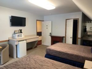 Room with mini fridge , microwave and tv at Peaks Lodge in Revelstoke, BC